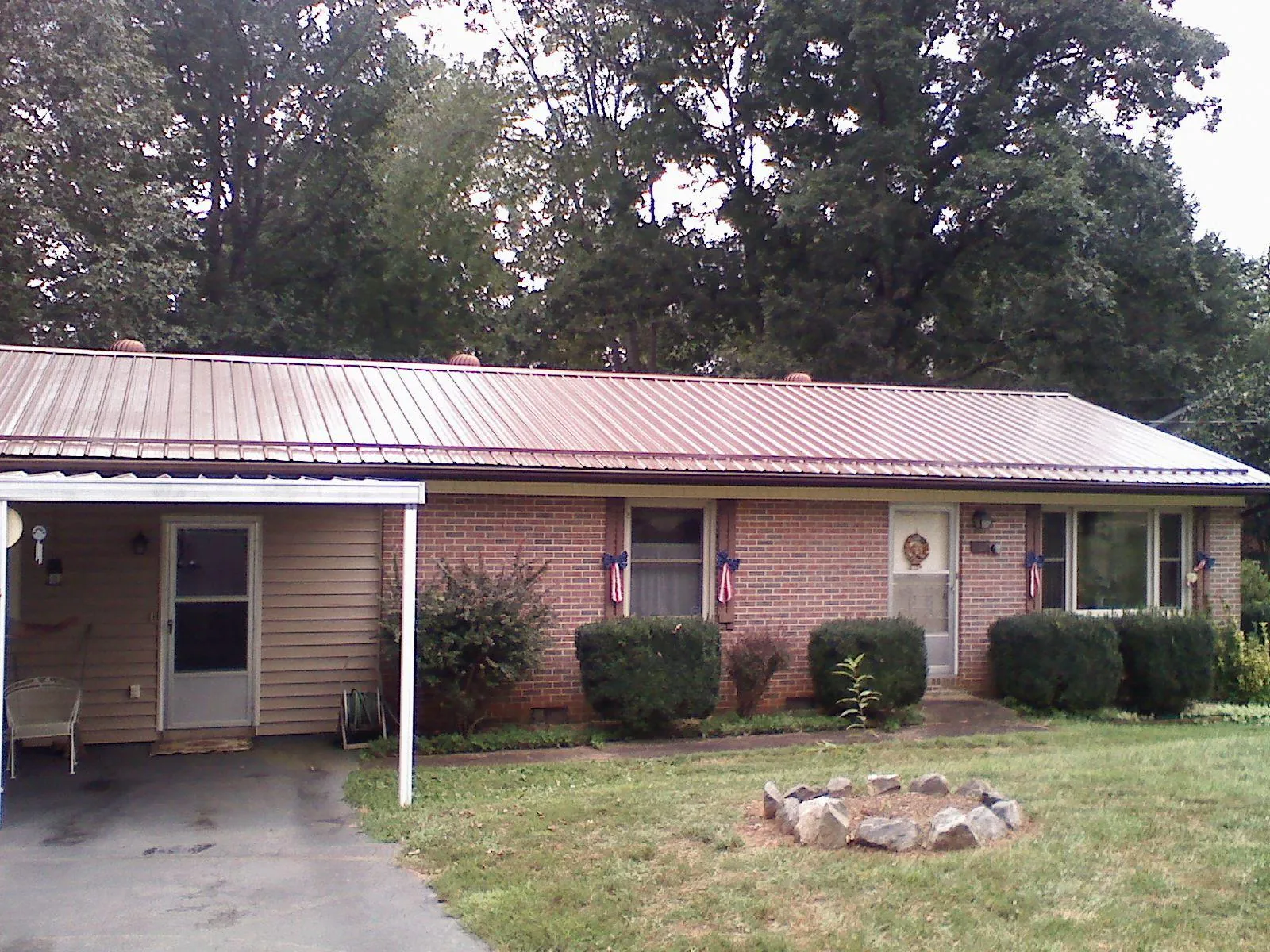 Bronze metal roof and carport on a brick ranch home — Roof Repair work by our crew in Van Etten